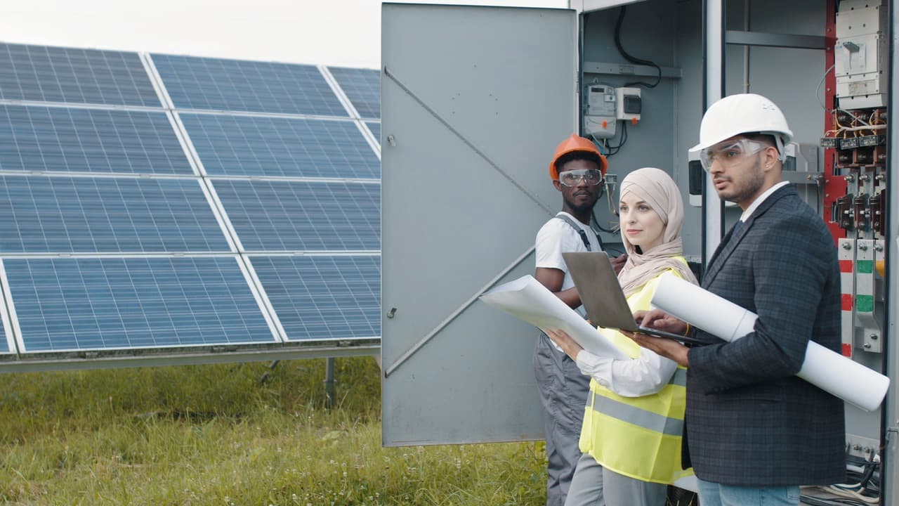 The Green Subsidy team building the system on-site, laptop and plans in hand